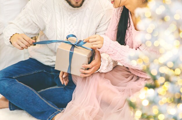 Presentes de natal nas mãos de um homem e de uma mulher. foco seletivo. feriado.