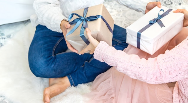 Presentes de Natal nas mãos de um homem e uma mulher. Foco seletivo.