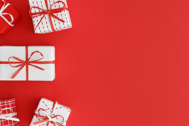 Presentes de natal vermelho e branco em um fundo vermelho Flat lay com espaço de cópia em branco