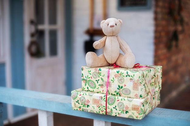 Presentes do urso de pelúcia do papai noel na varanda de casa esperando um filho
