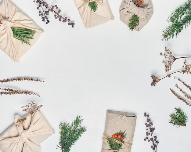 presentes embrulhados em tecido com decoração vegetal