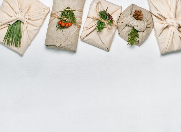 Presentes embrulhados em tecido com decoração vegetal