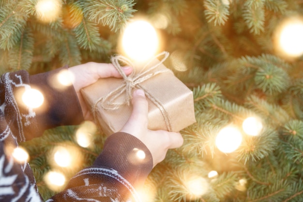 Presentes embrulhados na mão em uma árvore de Natal com copyspace. Caixa de presente de natal