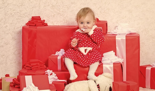 Presentes para crianças no primeiro Natal Menina brinca perto de uma pilha de caixas de presentes Férias em família Coisas para fazer com crianças no Natal Presentes de Natal para crianças Comemore o primeiro Natal