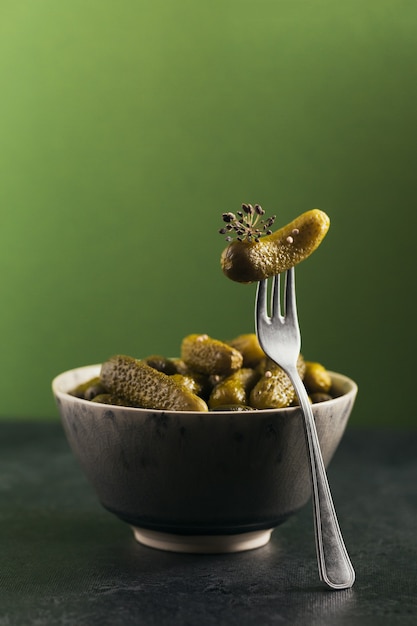 Preservando pepinos em conserva, temperos e alho em um fundo verde. alimentos fermentados saudáveis. vegetais enlatados caseiros.