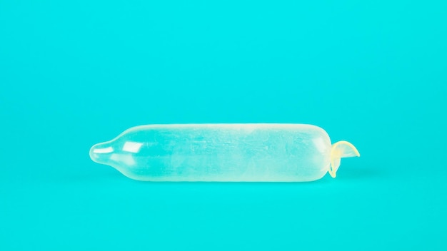Preservativo em um fundo azul O conceito de sexo seguro