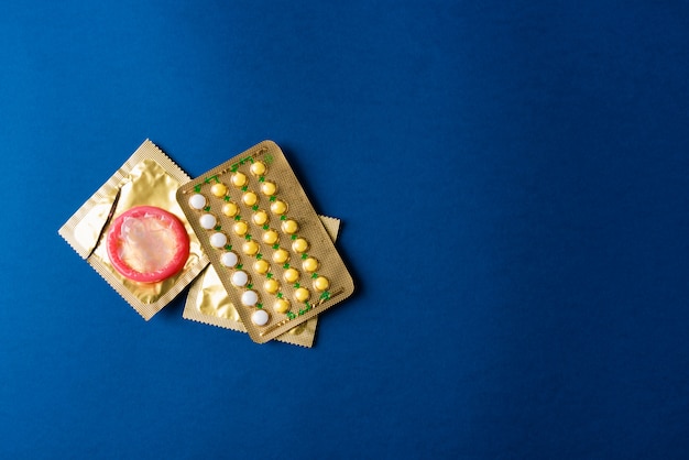Preservativo na embalagem e pílulas anticoncepcionais com bolhas nas pílulas anticoncepcionais hormonais