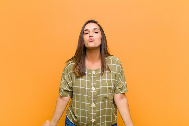 Foto presionando los labios con una expresión linda, divertida, feliz y encantadora, enviando un beso