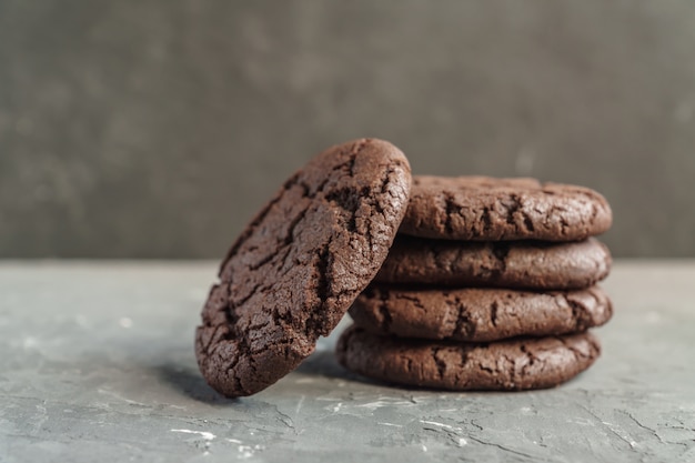 Preso de cookies de brownie de chocolate no fundo escuro de concreto