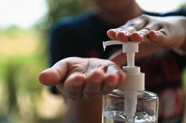 Pressione o gel de álcool da garrafa e aplique o desinfetante para as mãos, faça o vírus da limpeza covid 19