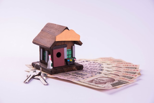 Préstamo o compra de financiación y vivienda en la India: concepto que muestra el modelo de casa en 3D, billetes y calculadora de la moneda india, etc.