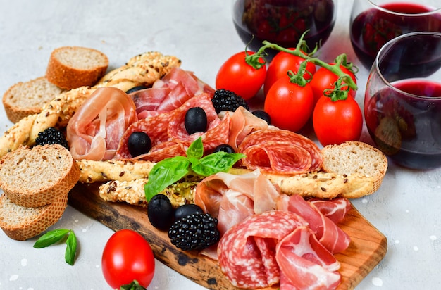 presunto de antepastos italiano, salame, azeitonas bresaola tomates e palitos de pão de grissini. aperitivo happy hour