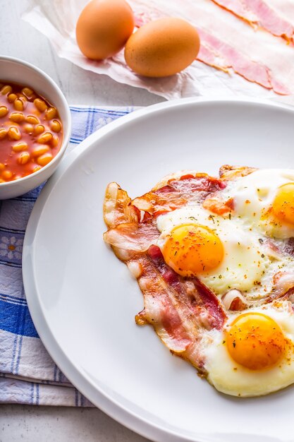 Presunto e ovos. bacon e ovos. ovo salgado e polvilhado com pimenta vermelha. café da manhã inglês.