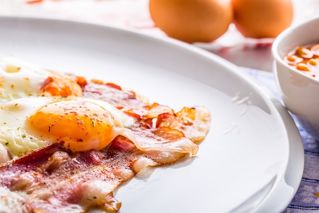 Presunto e Ovos. Bacon e Ovos. Ovo salgado e polvilhado com pimenta vermelha. Café da manhã inglês.