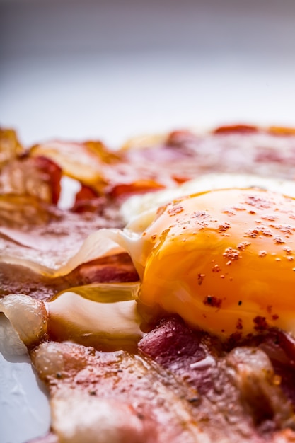 Presunto e Ovos. Bacon e Ovos. Ovo salgado e polvilhado com pimenta vermelha. Café da manhã inglês.