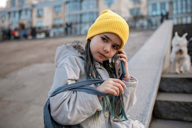 Preteen Mädchen sitzt auf Straßentreppe und SMS mit Smartphone smart