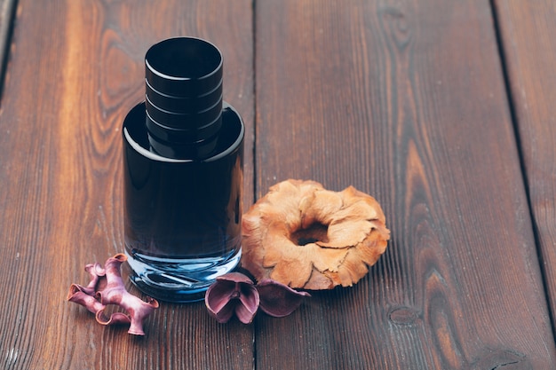 Preto frasco de perfume colocado sobre uma mesa de madeira