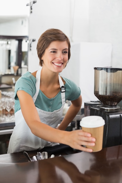 Pretty barista segurando copo descartavel