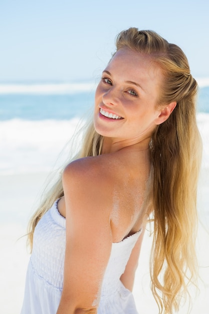 Pretty blonde despreocupado sorrindo para a câmera na praia