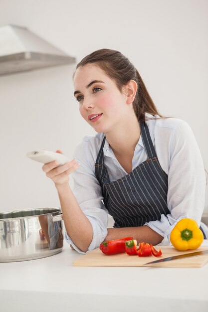 Pretty brunette cooking and watching tv