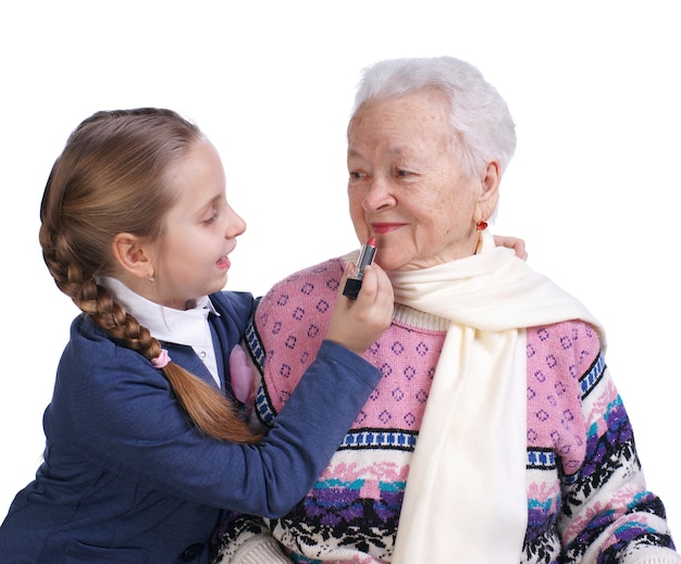 Pretty girl rouging los labios de las abuelas sobre un fondo blanco.