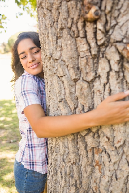 Pretty morena abrazando el árbol