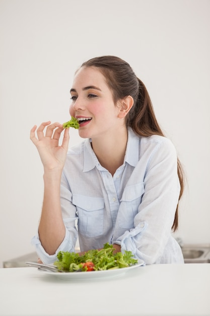 Pretty morena comendo tigela de salada