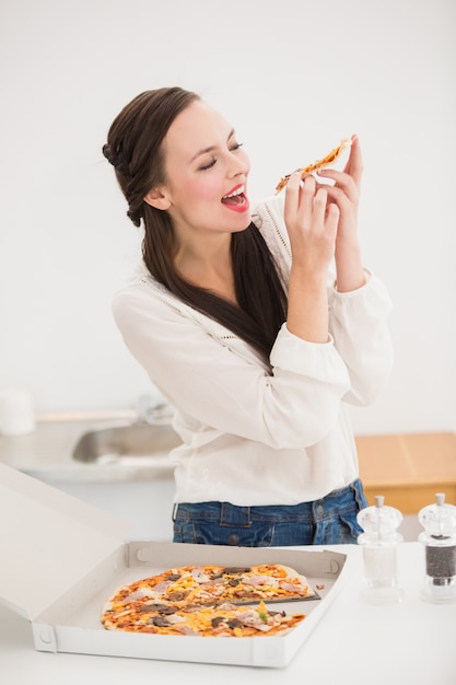 Pretty morena comiendo rebanada de pizza