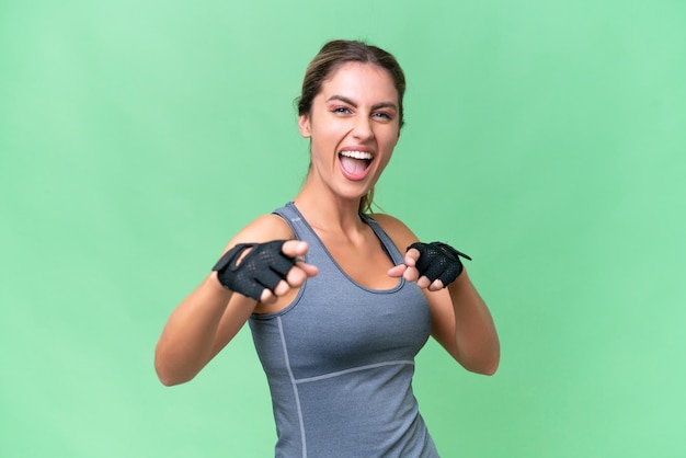 Pretty Sport mujer uruguaya sobre antecedentes aislados apuntando al frente y sonriendo