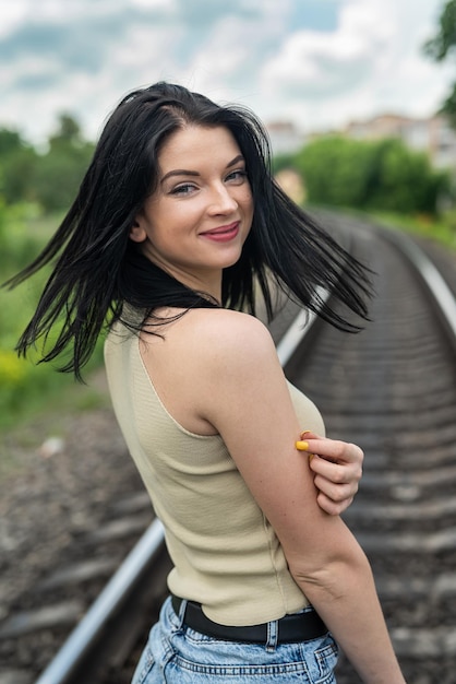 Prety lady aproveita o horário de verão nos trilhos do trem na natureza