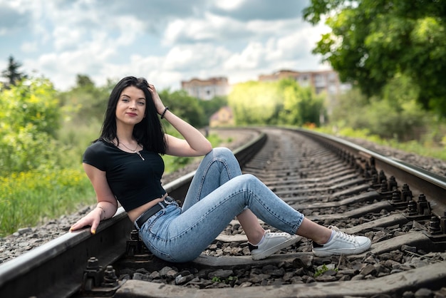 Prety lady disfruta del verano en la vía del tren en la naturaleza