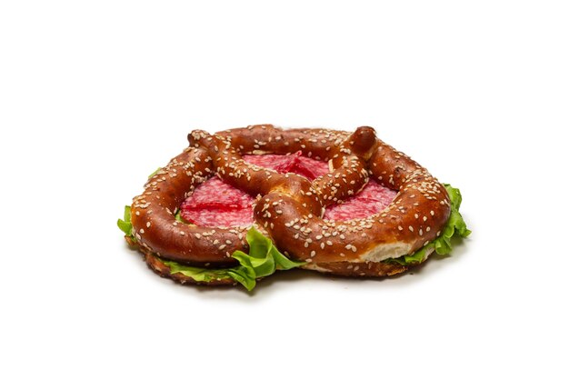 Pretzel com salame e alface, isolado em um fundo branco. Lanche saboroso.