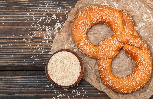 Pretzel con semillas de sésamo en la mesa de madera oscura