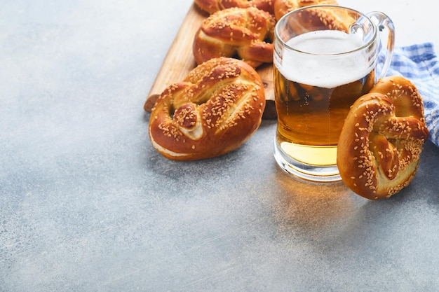 Pretzels bávaros e copo de cerveja lager Oktoberfest menu de comida tradicional pretzels salgados em fundo cinza claro Vista superior com espaço para texto tema Oktoberfest