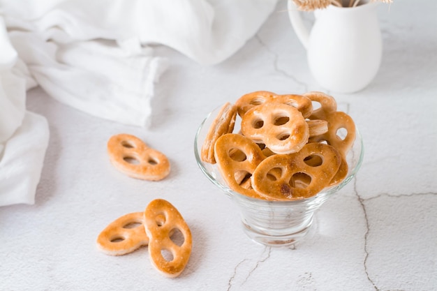 Pretzels bávaros en un recipiente de vidrio sobre la mesa. Merienda para comida rápida. De cerca