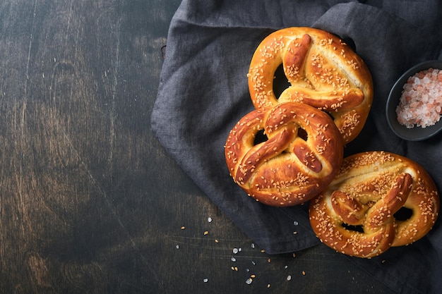 Pretzels bávaros y vaso de cerveza lager Menú de comida Oktoberfest pretzels salados tradicionales sobre fondo de madera oscura vieja Vista superior con espacio para texto Tema de Oktoberfest