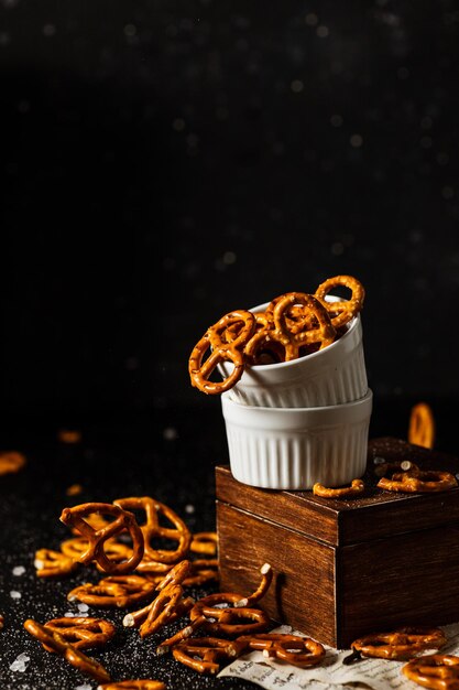 Pretzels com sal caem de um copo branco.