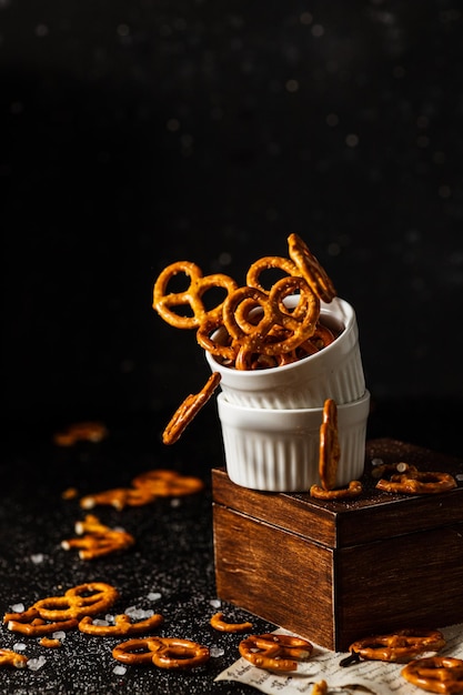 Pretzels com sal caem de um copo branco.