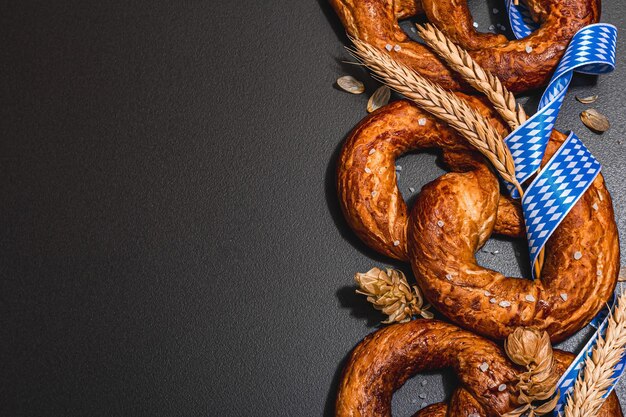 Pretzels de concepto de oktoberfest con cinta de patrón tradicional y espigas de trigo