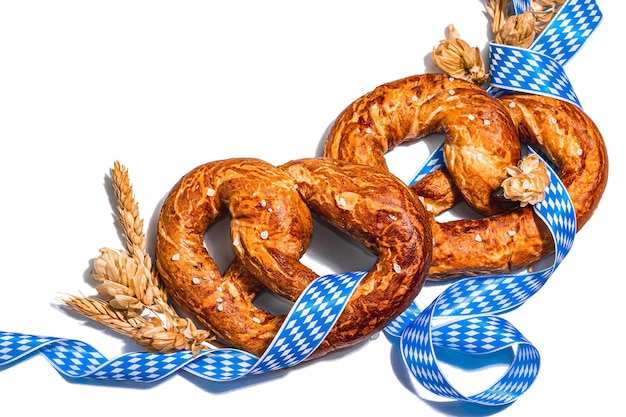 Pretzels de concepto de oktoberfest con cinta de patrón tradicional y trigo de orejas aislado en blanco