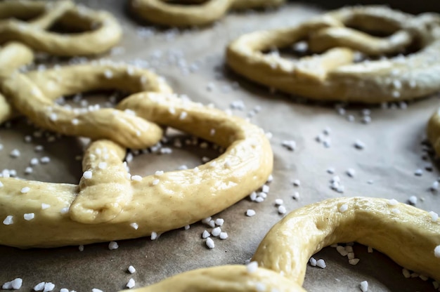 Pretzels crus com sal colocados na bandeja e prontos para assar no forno Comida tradicional Oktoberfest