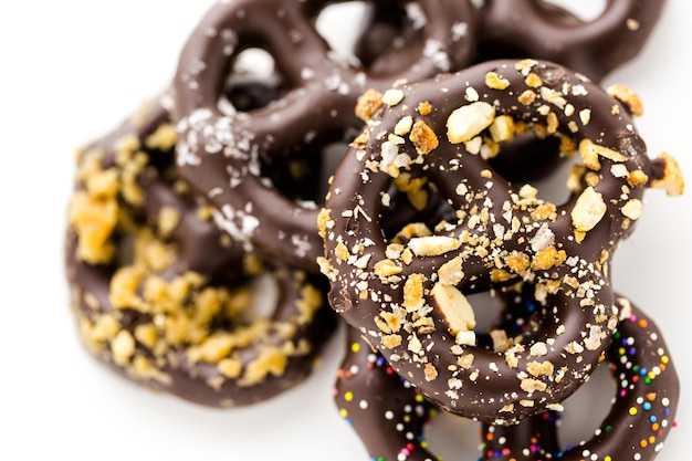 Pretzels cubiertos de chocolate gourmet sobre un fondo blanco.