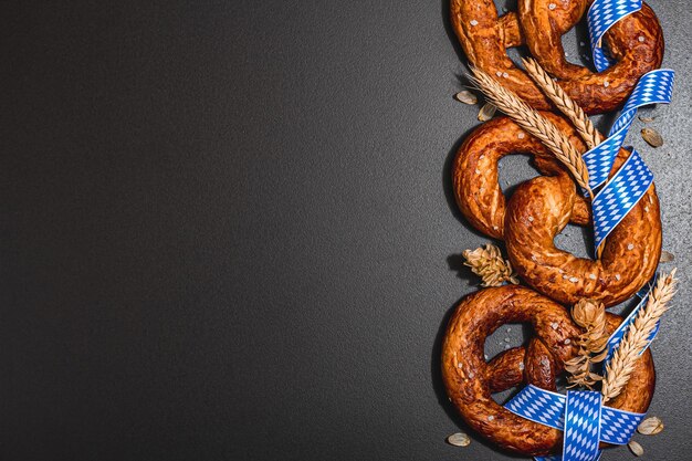 Pretzels do conceito Oktoberfest com fita de padrão tradicional e espigas de trigo