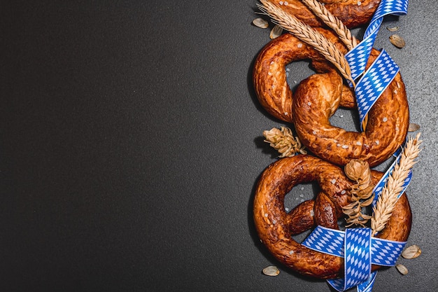 Pretzels do conceito Oktoberfest com fita de padrão tradicional e espigas de trigo