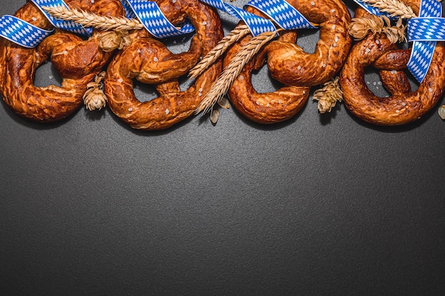 Pretzels do conceito Oktoberfest com fita de padrão tradicional e espigas de trigo