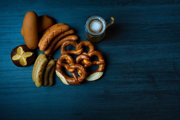 pretzels e linguiças da oktoberfest com jarra de cerveja na mesa de madeira estilo de comida escura