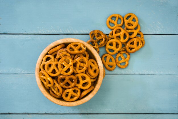 Pretzels em tigela na vista superior de mesa de madeira azul