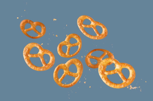 Los pretzels salados están esparcidos sobre un fondo azul.