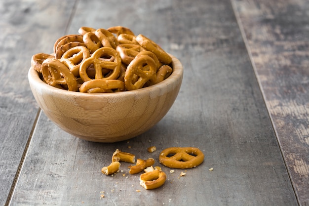 Pretzels salados en un tazón sobre fondo de madera copia espacio