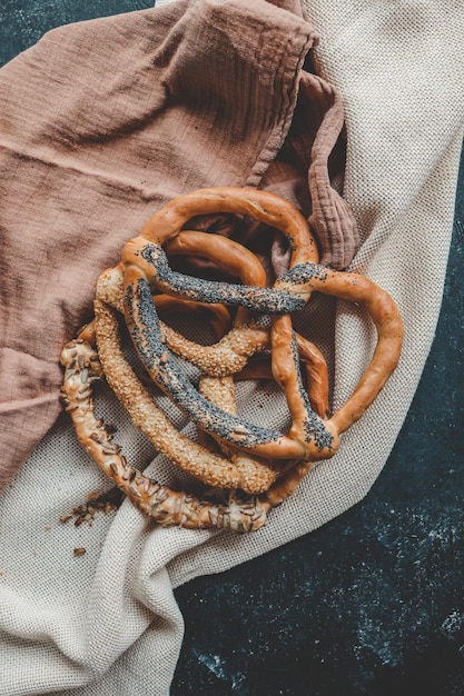 Pretzels suaves caseros recién preparados Diferentes tipos de pretzels horneados con semillas sobre un fondo negro